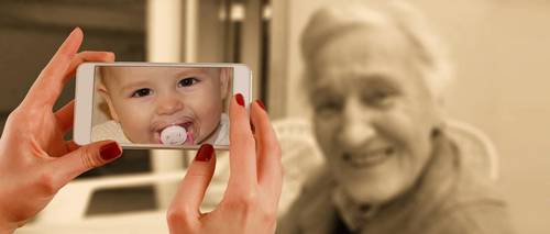 Alte Frau ist, betrachtet durch das Smartphone, jung